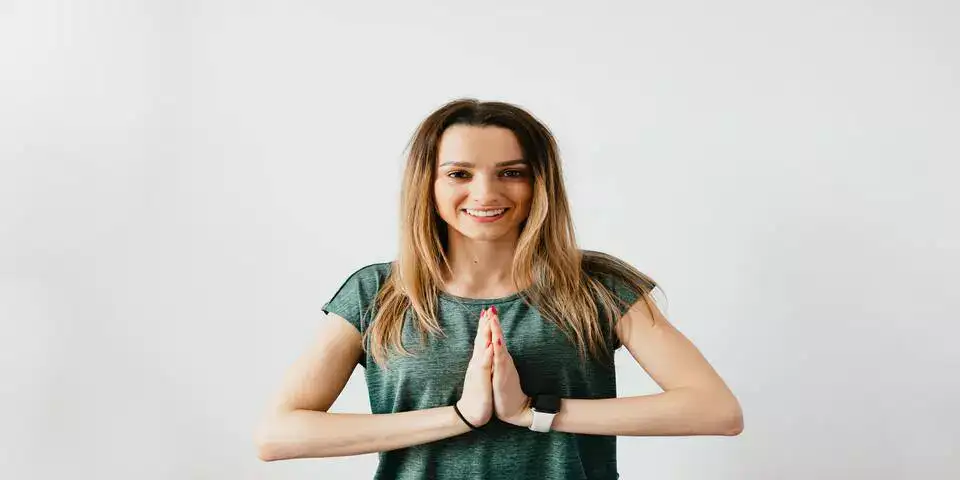 a girl standing in namaste posture a girl standing in namaste posture